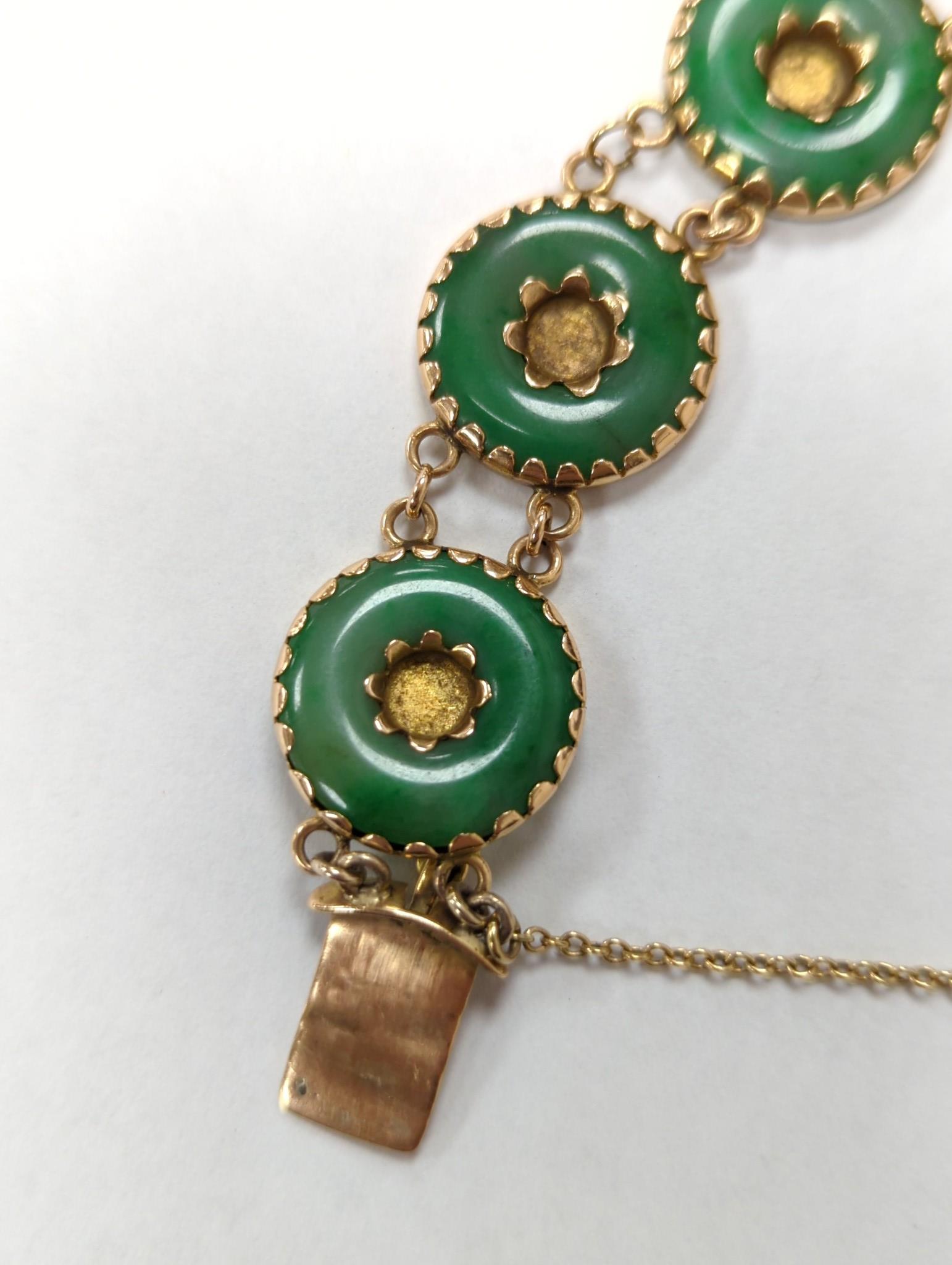 A Chinese yellow metal (stamped 18) and pierced eight stone jade disc set bracelet, with central Chinese characters, 16.5cm approx. gross weight 27.7 grams.